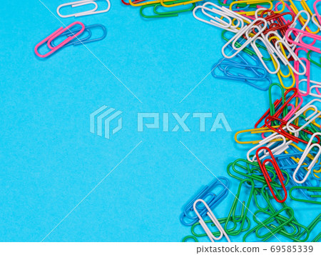 Colored paper clips on blue background 69585339