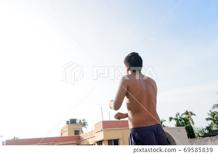 A man flying Kite in the sky. Kites flying picture with blue sky and white clouds. Photography in the eve of Vishwakarma Puja in Kolkata. 69585839