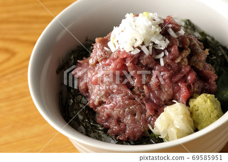 A pile of tuna sukimi-don with chopped seaweed on which gari and wasabi are also on board A pile of tuna sukimi-don with chopped seaweed on which gari and wasabi are also on board 69585951