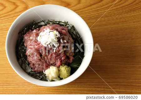 A heaping tuna bowl with chopped seaweed on which gari and wasabi are also on board (overhead view) A heaping tuna bowl with chopped seaweed on which gari and wasabi are also on board (overhead view) 69586020