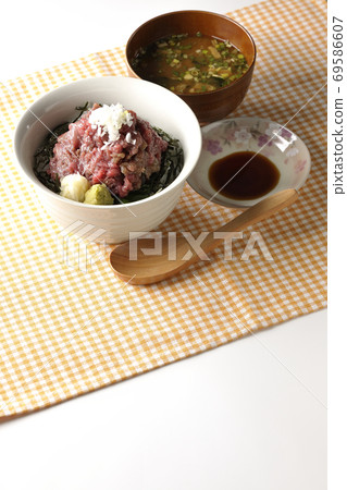Heaping tuna rice bowl with chopped seaweed on a place mat, miso soup, soy sauce, and a wooden spoon Heaping tuna rice bowl with chopped seaweed on a place mat, miso soup, soy sauce, and a wooden spoon 69586607