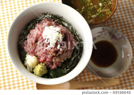 Heaping tuna bowl with chopped seaweed on a place mat, miso soup, soy sauce, and a wooden spoon (overhead view) Heaping tuna bowl with chopped seaweed on a place mat, miso soup, soy sauce, and a wooden spoon (overhead view) 69586640