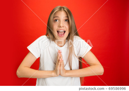 Portrait of young caucasian woman with bright emotions on bright red studio background Portrait of young caucasian woman with bright emotions on bright red studio background 69586996