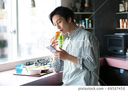 男人在廚房裡吃早餐 男人在廚房裡吃早餐 69587458