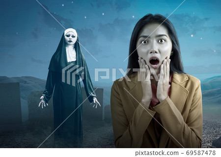 Asian businesswoman scared looking at frightening devil nun 69587478