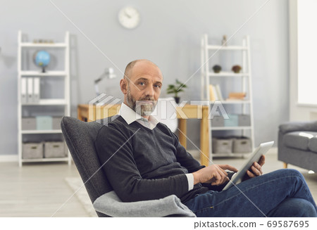 Mature man with tablet computer working online, chatting with family, consulting doctor or watching webinar at home 69587695