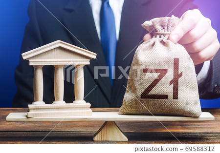 Businessman puts a polish zloty money bag on scales opposite to government state building. Lending to government projects. Payment of taxes and fees. Budgeting. Financing Social programs. Bank deposit 69588312