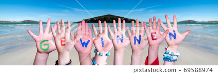 Children Hands Building Word Gewinnen Means Win, Ocean Background 69588974