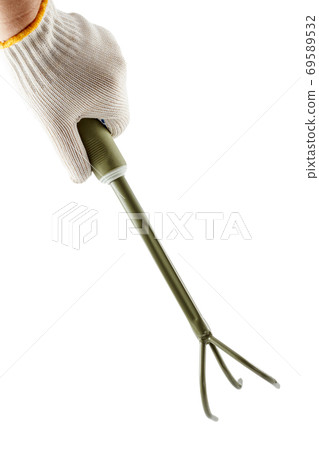 Small garden rake in hand dressed in a glove Small garden rake in hand dressed in a glove 69589532