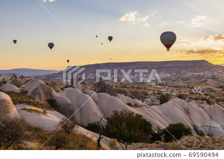 Hot air balloons flying over a volcanic landscape at Cappadocia, Turkey Hot air balloons flying over a volcanic landscape at Cappadocia, Turkey 69590494