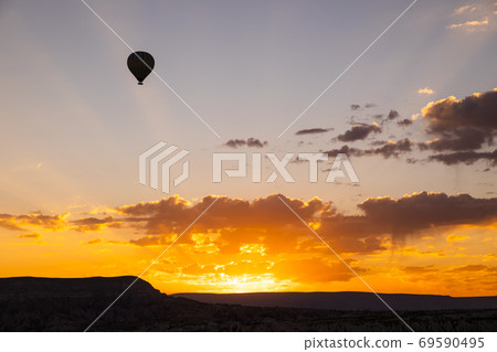 Hot air balloons flying over a volcanic landscape at Cappadocia, Turkey 69590495