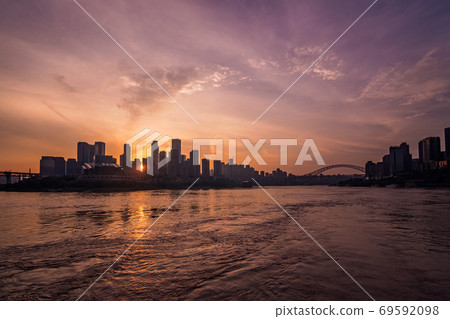 Silhouettes of buildings surrounded by the Yangtze river under the sunlight during the sunset in Chongqing 69592098