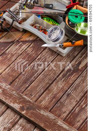 Different fishing tacles with rod and reels on wooden brown background. Different fishing tacles with rod and reels on wooden brown background. 69594705