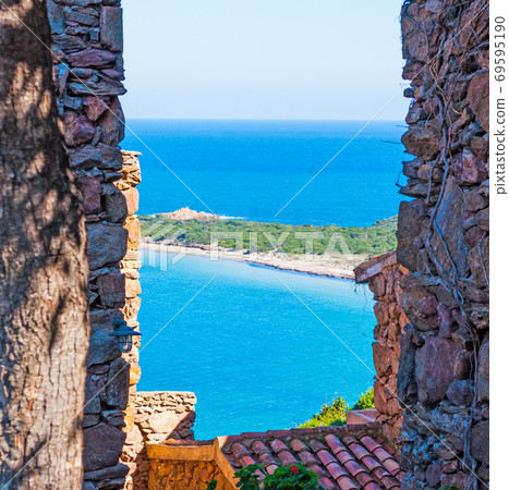 Capo Coda Cavallo shore seen through a rustic wall Capo Coda Cavallo shore seen through a rustic wall 69595190