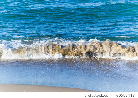 Small wave on the foreshore 69595418