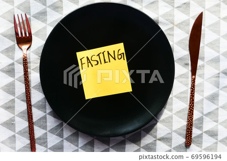 top view of fating word on sticky note on empty plate . top view of fating word on sticky note on empty plate . 69596194