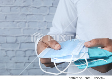 man hand holding surgical face mask, close up man hand holding surgical face mask, close up 69596200