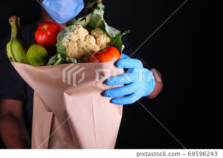 young man with protective mask and gloves delivery goods. young man with protective mask and gloves delivery goods. 69596243