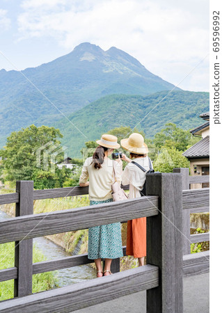 一名年輕女子和一位朋友在女孩出遊時用智能手機拍攝由布岳[9月] 69596992