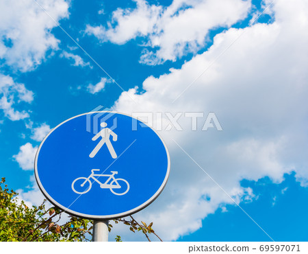 Pedestrian and bike sign under a cloudy sky 69597071