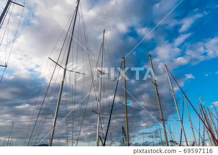Boats masts under clouds 69597116