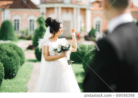 Bride holding big and beautiful wedding bouquet with flowers Bride holding big and beautiful wedding bouquet with flowers 69598398
