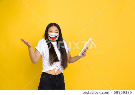 Portrait of young girl with emotion on her protective face mask isolated on studio background. Beautiful female model, funny expression Portrait of young girl with emotion on her protective face mask isolated on studio background. Beautiful female model, funny expression 69599389