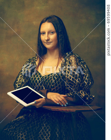 Young woman as Mona Lisa on dark background. Retro style, comparison of eras concept. 69599408