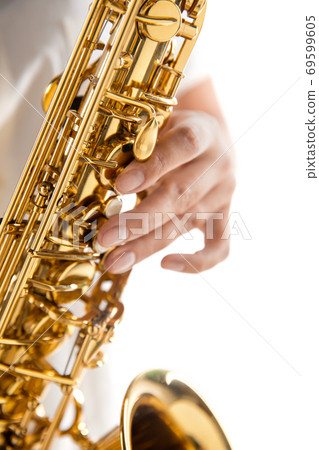 Close up woman playing saxophone isolated on white studio background Close up woman playing saxophone isolated on white studio background 69599605