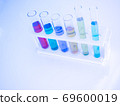 The test tube has a multicolored liquid inside. Put on a table for science experiments, color tones. 69600019