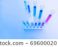 The test tube has a multicolored liquid inside. Put on a table for science experiments, color tones. 69600020