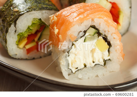 Close up Uramaki Philadelphia. Sushi rolls with salmon, nori, rice and cheese Close up Uramaki Philadelphia. Sushi rolls with salmon, nori, rice and cheese 69600281
