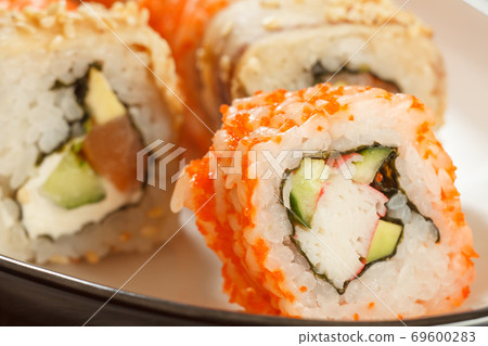 Close up Uramaki California. Sushi roll with nori, rice, avocado and crab sticks 69600283