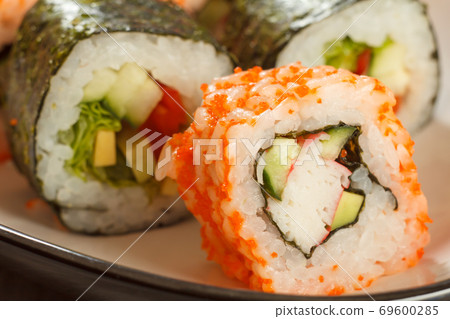 Close up Uramaki California. Sushi roll with nori, rice, avocado and crab sticks 69600285