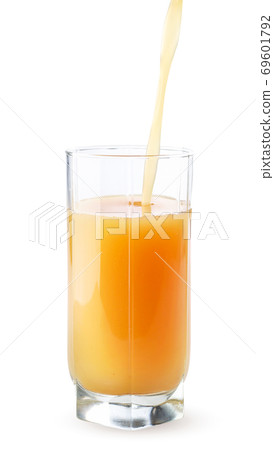 Fruit juice is poured into a glass cup on a white background. Isolated 69601792