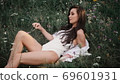 Woman in white swimsuit lying on the grass enjoying nature 69601931