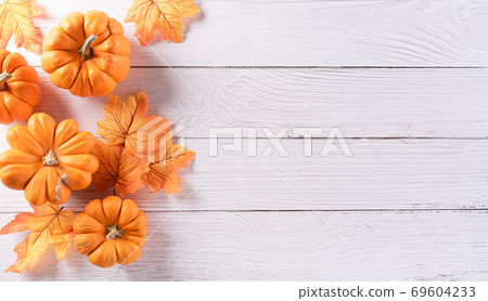 Autumn background decoration from dry leaves and pumpkin on wooden background. Flat lay, top view with copy space for Autumn, fall, Thanksgiving concept. Autumn background decoration from dry leaves and pumpkin on wooden background. Flat lay, top view with copy space for Autumn, fall, Thanksgiving concept. 69604233