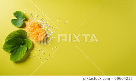Happy Dussehra background concept. Green leaf and rice on yellow pastel background. Dussehra Indian Festival concept. Happy Dussehra background concept. Green leaf and rice on yellow pastel background. Dussehra Indian Festival concept. 69604235