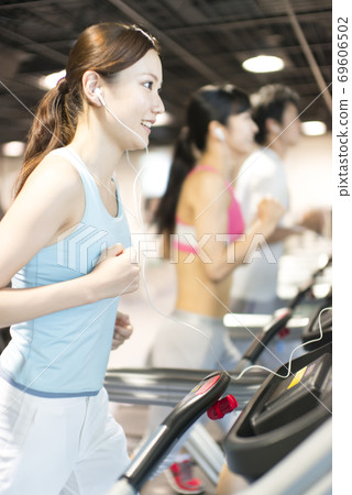 Men and women running on running machines Men and women running on running machines 69606502
