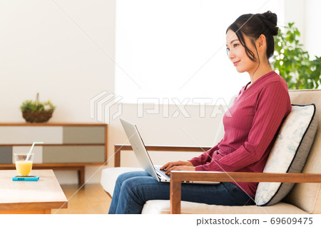 坐沙發和操作計算機的婦女 69609475