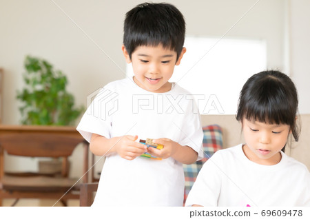 兄弟姐妹在客廳的桌子上玩積木 69609478
