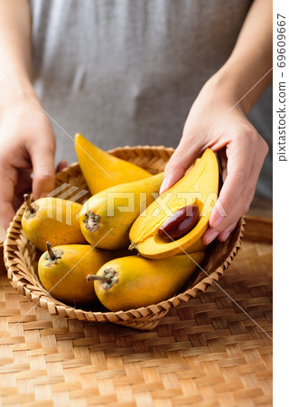 Eggfruit or canistel in a basket holding by hand, Thai fruit 69609667