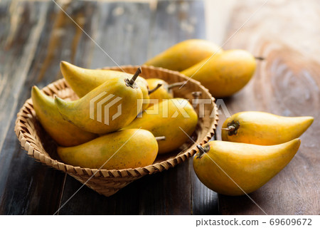Eggfruit or canistel in a basket on wooden table, Thai fruit Eggfruit or canistel in a basket on wooden table, Thai fruit 69609672