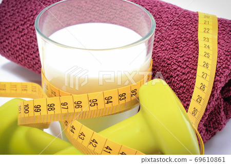 Tape measure, glass of milk and accessories using in fitness. Slimming, healthy sporty lifestyles Tape measure, glass of milk and accessories using in fitness. Slimming, healthy sporty lifestyles 69610861