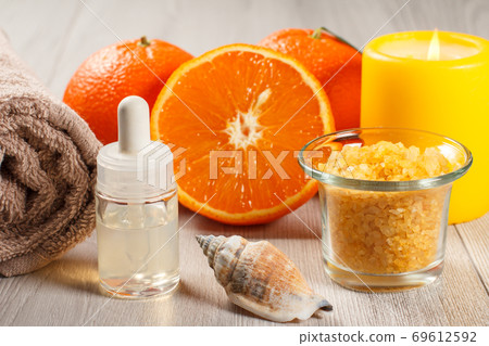 Cut orange with two whole oranges, towel, sea shell, bottle with aromatic oil Cut orange with two whole oranges, towel, sea shell, bottle with aromatic oil 69612592