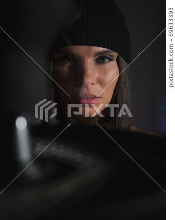 Brunette smoking hookah in dark room 69613393