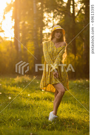 Blond woman resting in forest at sunset Blond woman resting in forest at sunset 69613395