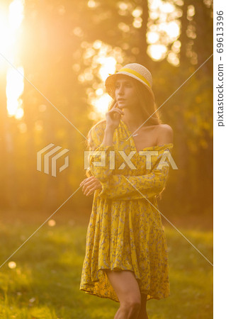 Blond woman resting in forest at sunset Blond woman resting in forest at sunset 69613396