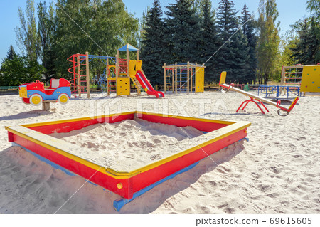 Empty playground in sunny day. Playground for toddlers and kids with nobody there. Kindergarten, primary school playground background. Nobody on playground. Ground outdoor. Quarantine and children Empty playground in sunny day. Playground for toddlers and kids with nobody there. Kindergarten, primary school playground background. Nobody on playground. Ground outdoor. Quarantine and children 69615605