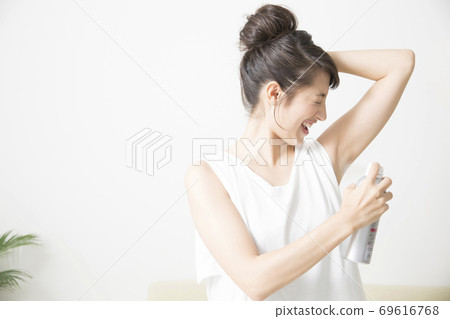 A woman with a deodorant spray A woman with a deodorant spray 69616768